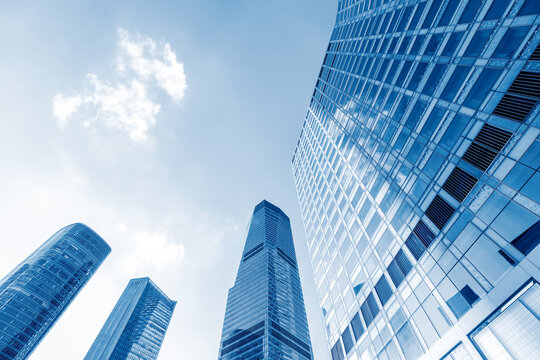 Fototapeta Modern office building with glass facade on a clear sky background. Transparent glass wall of office building.