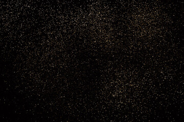 Fototapeta na wymiar Black festive background. Abstract scattering of gold sparkles on black. Holiday backdrop