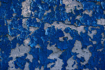 Concrete wall texture painted in blue. Cracked paint.