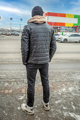 Obraz premium A man is waiting for a traffic light at an intersection on a winter day