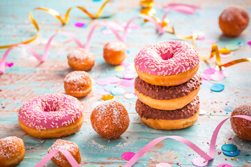 Krapfen, Berliner and donuts with streamers and confetti. Colorful carnival or birthday image