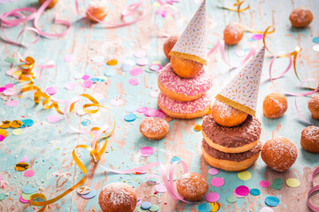 Krapfen, Berliner and donuts with streamers and confetti. Colorful carnival or birthday image