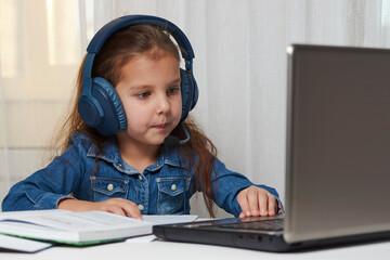 Child girl enjoy e-learning on computer notebook