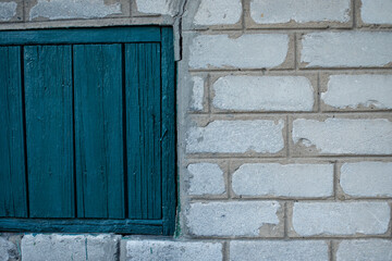 Brick wall with green pieces of wood.