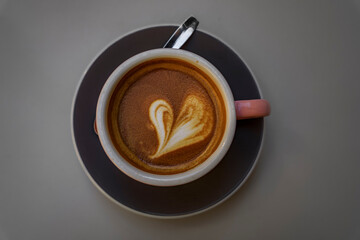 Close up on a cup of a hot coffee with a latte art heart design at a cafe in Donostia or San Sebastian, Spain