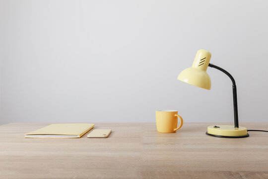 Yellow Items Notebook Cup And Lamp On Wooden Table