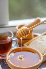 Honey in a bowl and in honeycombs still life by the window