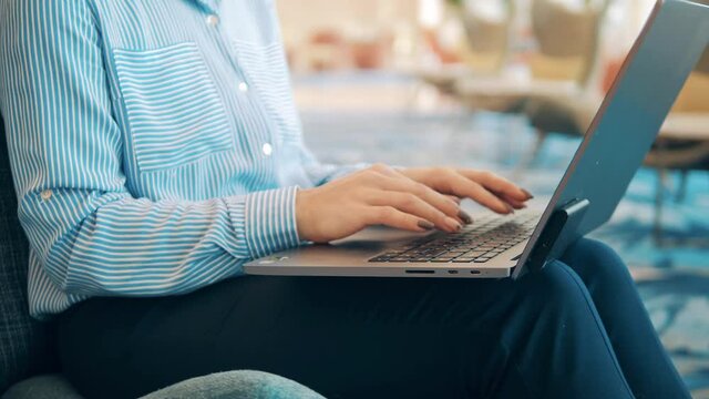 A Woman With Painted Nails Is Typing On Her Laptop