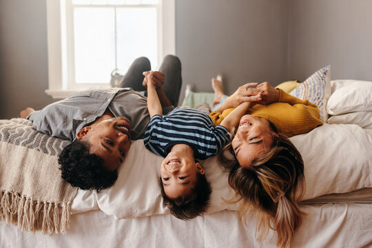 Happy family having fun together in their bedroom - Powered by Adobe