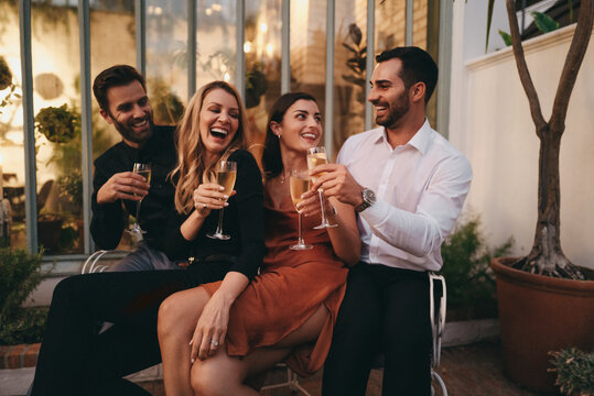 Smiling group of friends toasting champagne glasses