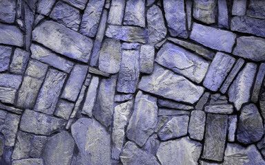 The wall natural stone, the masonry is stone on cement. Concept - stone wallpaper, background and decor, color 2022 very peri lavender