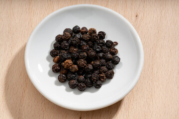 Detailed and large close up shot of peppercorns on a small plate