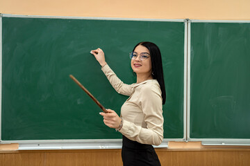 happy young teacher near blackboard in the classroom  at the school.