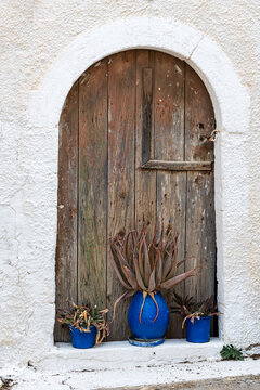 Flower pots in front of a wooden door in the small village Pitsidia in the south-central of Crete. The village has kept his original character and is a popular destination in the south of the island  