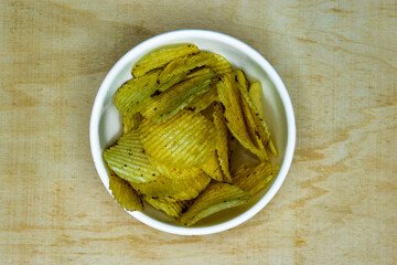 Salted Potato Wafers in Big White Bowl on Wooden Table, Heap of Wafers, Copy Space, Heap of Chips, Top View