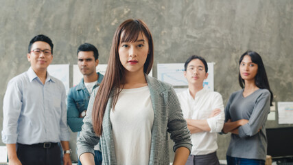 Portrait of successful businessman and businesswoman smart casual wear looking at camera and smile, arms crossed in creative office workplace. Diverse Asia male and female stand together at startup.