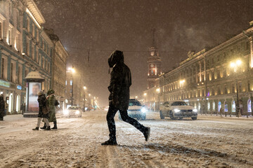 Snow storm in city. Pedestrian and drivers suffer from bad weather, slippery road, blizzard and strong wind. Snowy cyclone in winter town. City street at night with snowstorm and people walk outdoors - obrazy, fototapety, plakaty