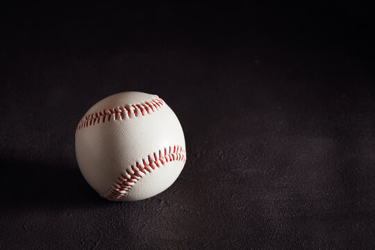 Baseball ball on dark brown background with copy space