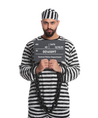 Prisoner with chained hands holding mugshot letter board on white background