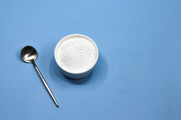Collagen powder on blue background. Natural health supplement for skin