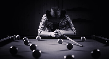 A man with a beard plays a big billiard. Party in a 12-foot pool. Billiards in the club game for men. A man with a cue breaks the pyramid. © alexkich
