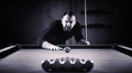 A man with a beard plays a big billiard. Party in a 12-foot pool. Billiards in the club game for...