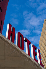 Signboard with giant red letters of hotel with blue sky in the background