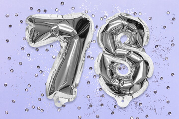 Silver foil balloon number, digit seventy eight on a lilac background with sequins. Birthday greeting card with inscription 78. Top view. Numerical digit. Celebration event, template.