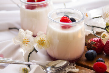 yogurt with wild berries on wooden background
