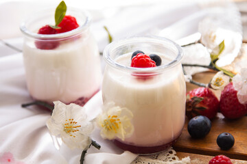 yogurt with wild berries on wooden background