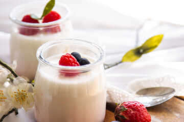 yogurt with wild berries on wooden background