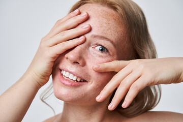 Smiling woman with naked shoulders and freckles at the face