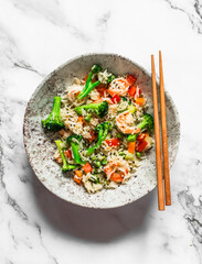 Asian style lunch - rice with shrimp and vegetables  on a light background, top view