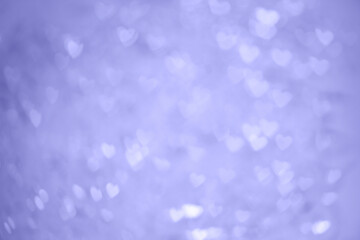 Natural purple bokeh of lights in the form of a heart, blurred out of focus background. Abstract beautiful backdrop for text or advertising. Postcard with love in light gentle colors