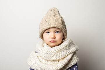 beautiful little baby in a hat on a light background. Concept of children's emotions, winter, shopping