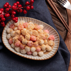 Deep-fried red and white tangyuan with peanut powder.