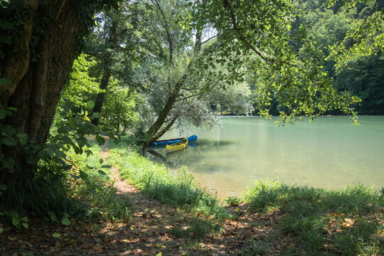 rowing boats on the river kolpa in the summertime surrounded by beautiful green forests
