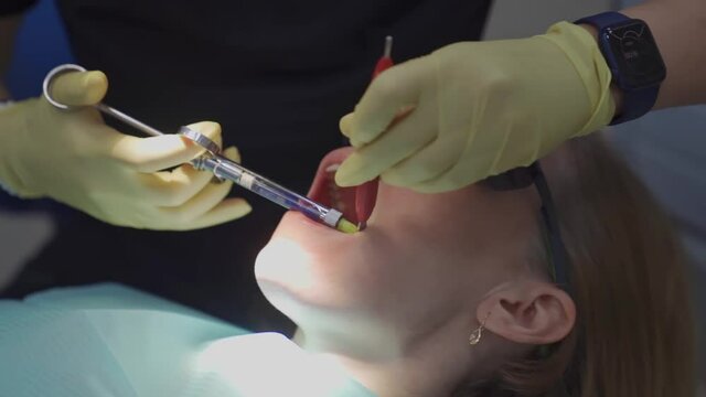 real. dentist injects an anesthetic into patient before tooth extraction