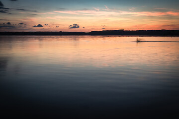 Naklejka na ściany i meble Beautiful sunset on the lake, reflection of clouds and moon, background