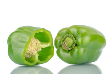 One whole organic, sweet green peppers and one half, close-up, isolated on white.