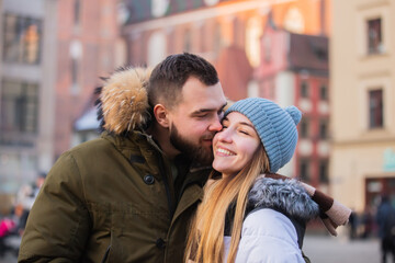 Beautiful couple, boyfriend and girlfriend are kissing on Christmas fair in Wroclaw, Poland