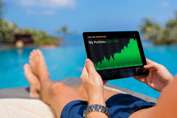 Man viewing his investments growth while sitting by the pool