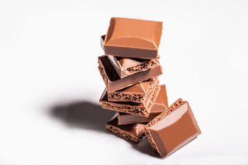 Porous chocolate lies in a pyramid on a white background.