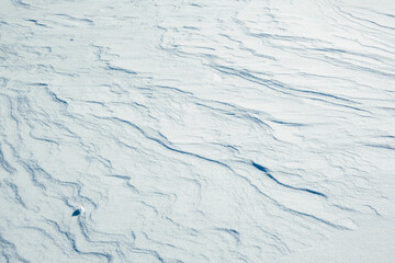 Snow texture with snow waves. Winter nature background.