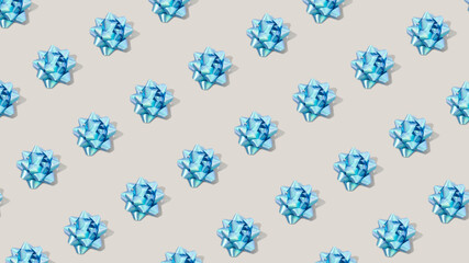 Minimal composition background of plastic blue decorative Christmas gift bows. New Year concept.