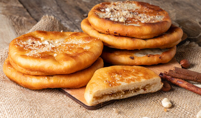 Fried dough dessert with various fillings on a wooden background. Hotteok is a South Korean dessert.