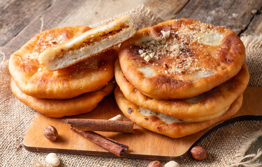 Sweet Korean pancakes made from fried yeast dough stuffed with nuts on a wooden table.