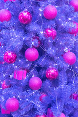 Christmas tree in a delicate purple color. Lilac trend shades of 2022. Christmas and New Year's Day.