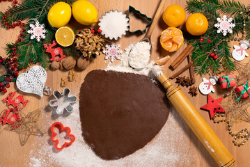 Dough and rolling pin for making Christmas gingerbread on the background of New Year's Christmas decor, top view
