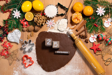 Dough and rolling pin for making Christmas gingerbread on the background of New Year's Christmas decor, top view